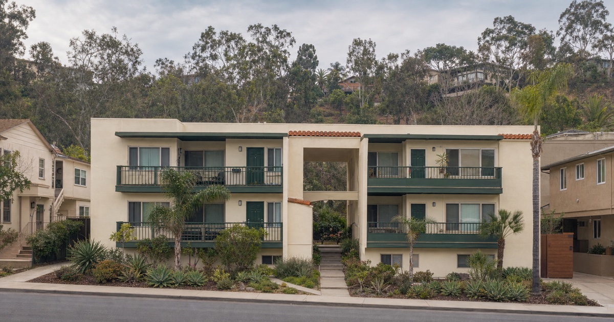 Cream and green City of San Diego apartment building at the edge of an urban canyon.