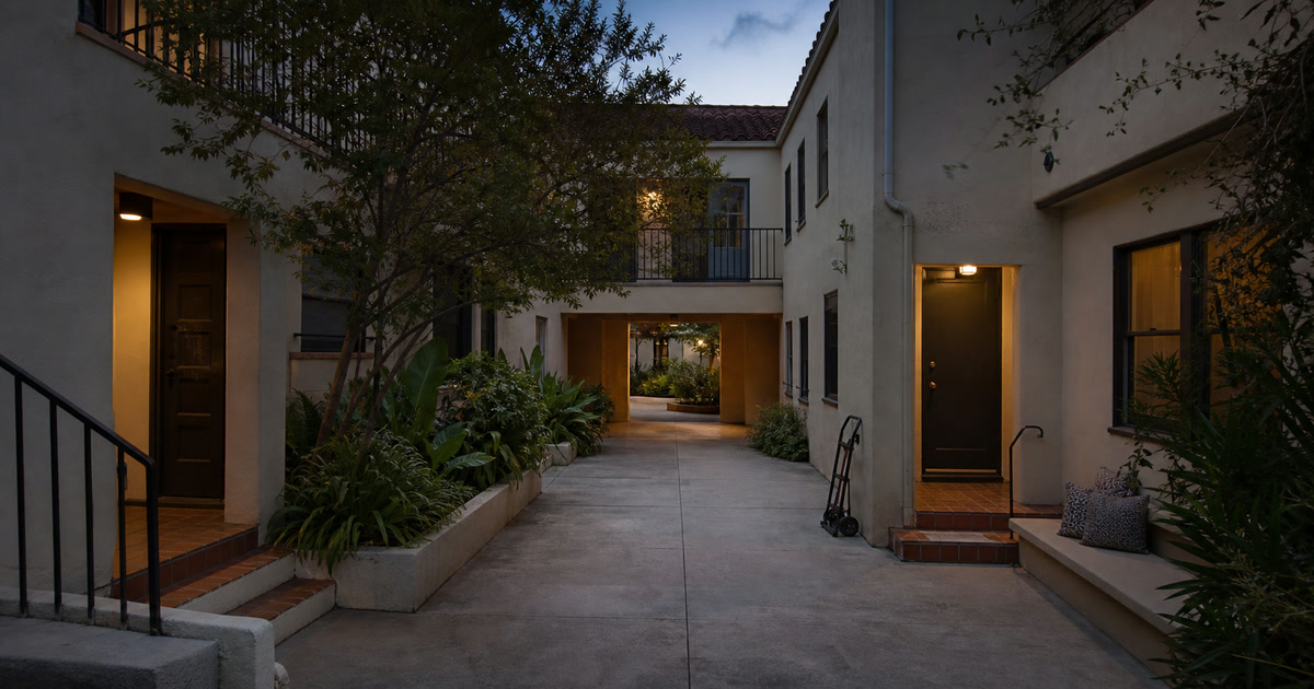 Quiet Los Angeles apartment courtyard at dusk with a folded moving dolly