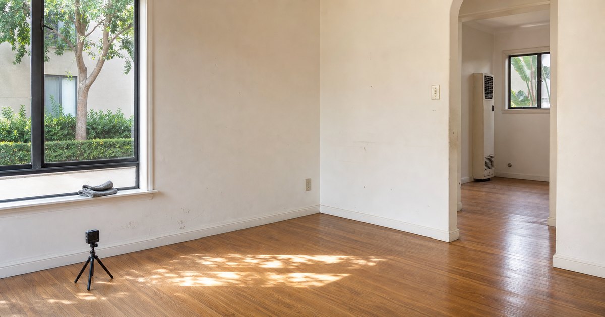 Empty California rental living room after move-out with ordinary wear and a camera ready to document condition