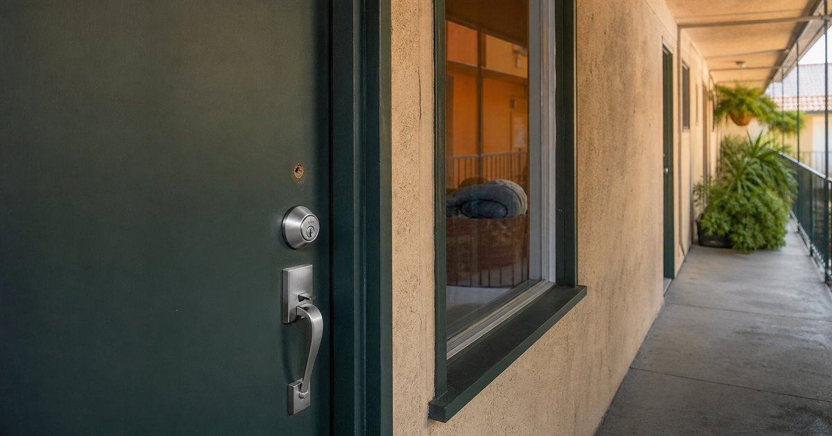 Close view of a California apartment door with newly changed lock hardware and no key present